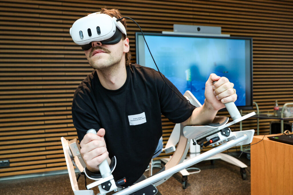 Das Bild zeigt einen Mann mit einer VR Brille, der in der Vorrichtung ICAROS liegt.